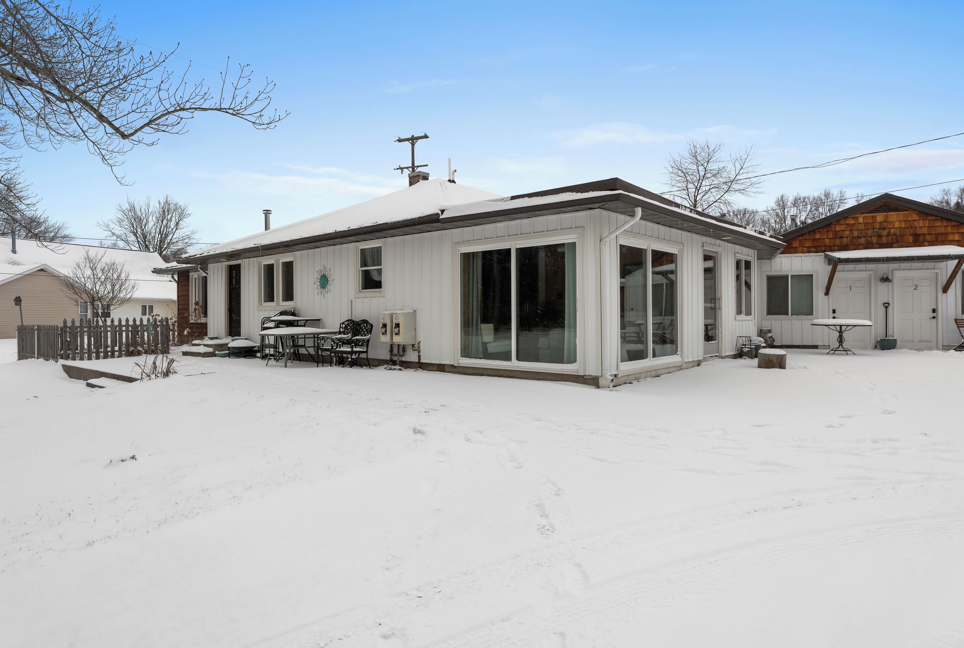 A single-story house with a covered patio, a fenced yard, and a garage.