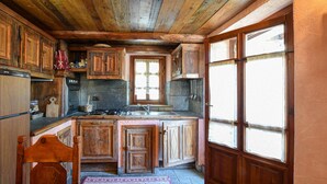 Een landelijke keuken met houten kastjes, een betegelde achterwand en een raam met uitzicht.