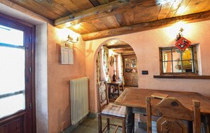 A rustic interior with a wooden table, chairs, a radiator, and a calendar on the wall. - Amazing apartment in Cogne (Cogne)