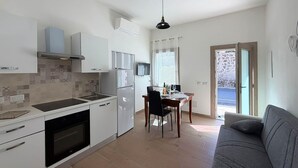 Eine moderne Küche mit weißen Schränken, einem eingebauten Backofen und einem Essbereich mit Tisch und Stühlen.
