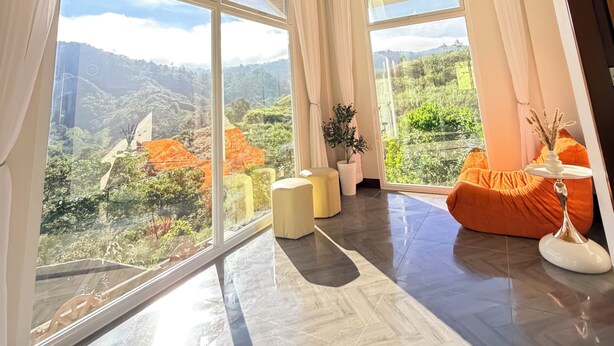 A spacious room with large windows, a wooden ceiling, and a chandelier. - Cozy Villa Mountain View Cold Weather in Marilog Perfect for Relaxing getaways (Arakan)