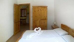 A bedroom with a bed, wooden wardrobe, and a heart-shaped towel on the bed. - 2 bedroom lovely apartment in Ricadi (Ricadi)