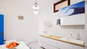 Una cucina moderna con un piano di lavoro bianco, un lavello e un lampadario.