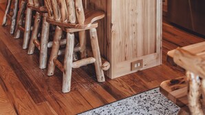 Eine rustikale Küche mit Holzausstattung, einer zentralen Kochinsel und einem Edelstahlkühlschrank.