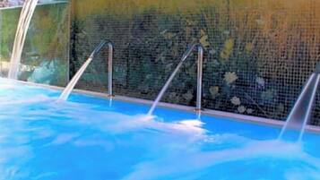 Una piscina con escaleras de metal y una pared de azulejos.
