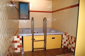 Ein Badezimmer mit Badewanne, Dusche und Fliesenboden.