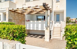 A covered outdoor area with a pergola, a stone wall, and a staircase leading to a building entrance. - 2 bedroom gorgeous apartment in Porto Cesareo (Porto Cesareo)