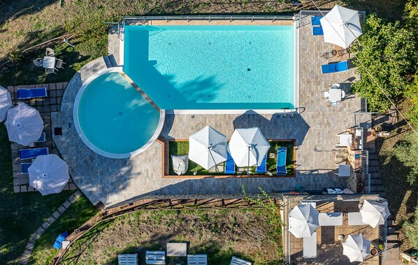 A rooftop pool with a circular hot tub, surrounded by lounge chairs and umbrellas. - Awesome apartment in Montecastelli Pisano (Montecastelli Pisano)