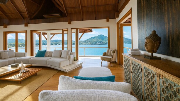 Un salon spacieux avec un grand canapé, une table basse et une vue sur un lac et des montagnes.