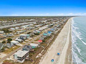 A coastal residential area with houses along the beach, a clear sky, and a view of the ocean. - Done Dune Stuff - Experience beachside bliss at a 4-bedroom retreat in Oak Island! (Oak Island)
