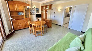 Un coin repas avec une table et des chaises en bois, un lustre et des meubles de rangement en bois.