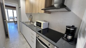 Une cuisine moderne équipée d’un four à micro-ondes, d’un grille-pain, d’une machine à café et d’un four.