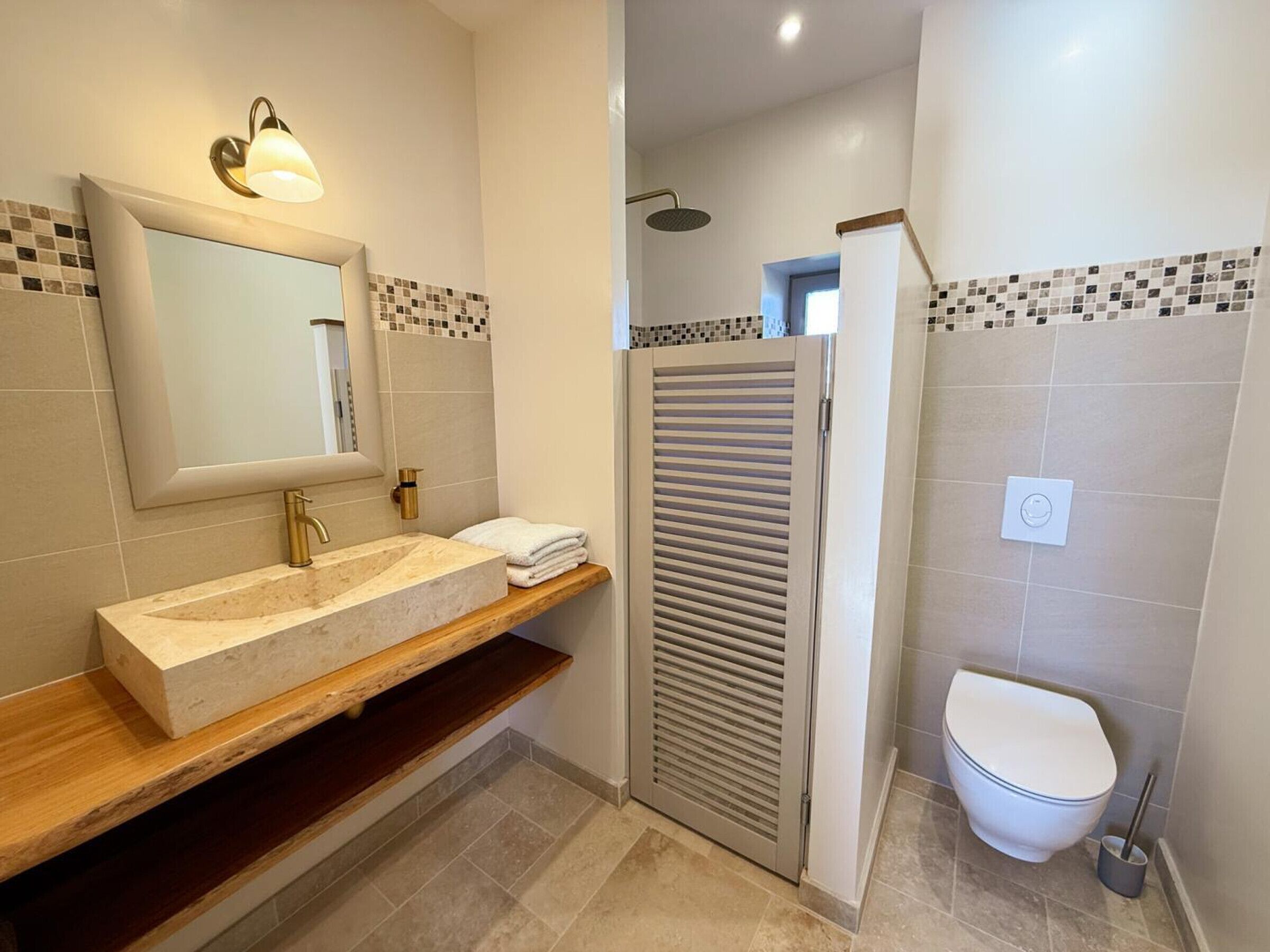 A bathroom with a vanity, a shower, and a toilet.