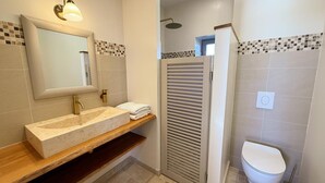 Ein Badezimmer mit Waschtisch, Dusche und Toilette.
