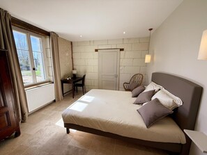 Ein Schlafzimmer mit Bett, Schreibtisch, Stuhl, einer Tür und einem Fenster.