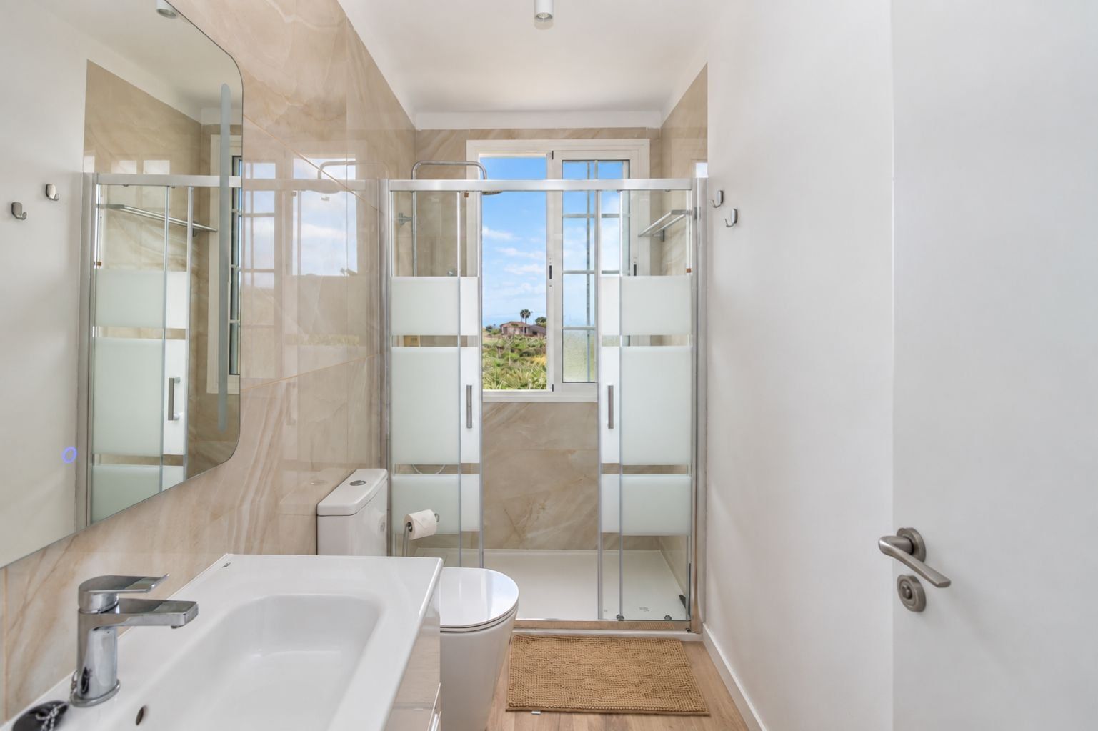 A modern bathroom with a bathtub, toilet, and shower area.