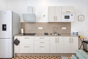 A compact kitchen with a refrigerator, microwave, sink, and cabinets. - GuestReady - El Refugio de Salomé Graja Real (Los Sauces)