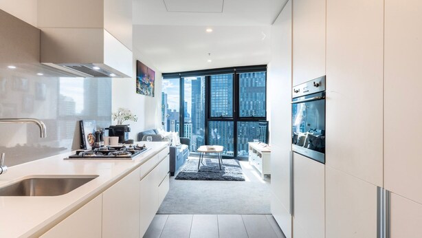 A modern kitchen with a large window, a dining area, and a view of the cityscape. - Southbank Skyline Suite - City Views & Prime Location (Southbank)