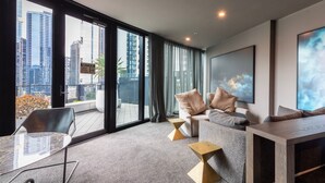 A modern living room with a city view, a sofa set, a coffee table, and a dining table. - Southbank Skyline Suite - City Views & Prime Location (Southbank)