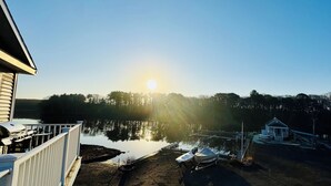 A lakeside property with a dock, a small cabin, and a boat. - The Nest at Black Hall (Old Lyme)