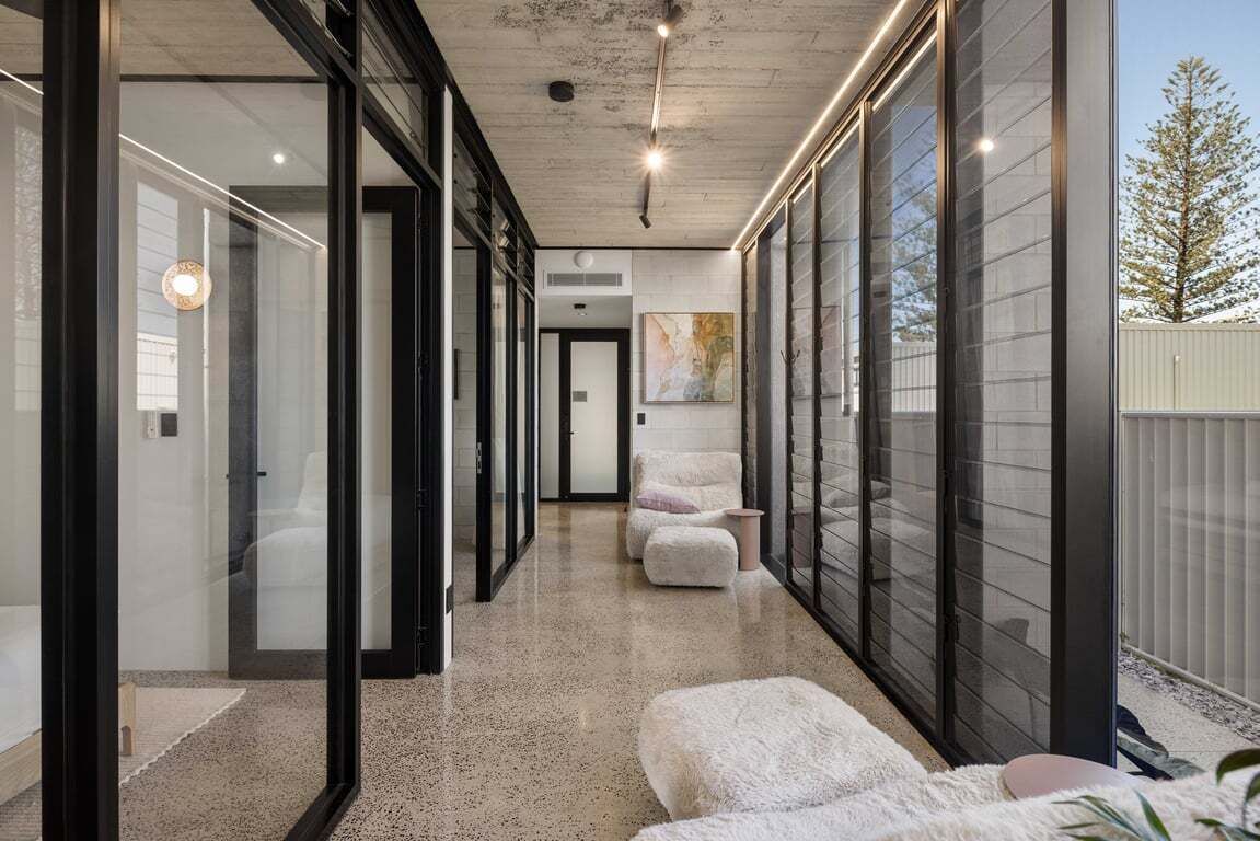 A modern hallway with glass doors, a concrete ceiling, and a view of the outdoors.