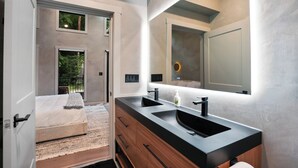 Une salle de bain moderne avec un double vasque, un meuble-lavabo en bois et un grand miroir.