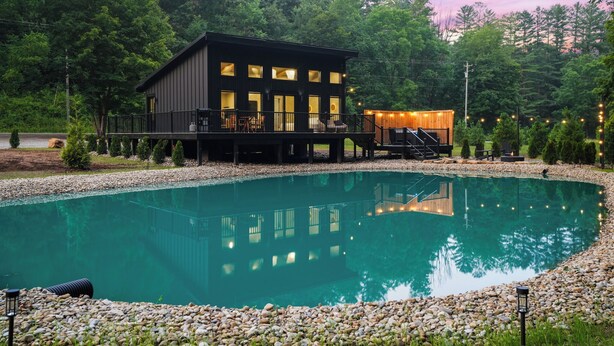 Une maison moderne dotée d’une piscine, d’une terrasse et donnant sur une forêt.