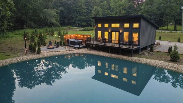 A modern house with a swimming pool, deck, and outdoor seating area. - New Listing! Luxury Pondside Cabin | Hot Tub (McArthur)