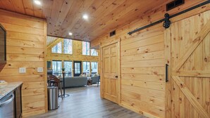 Interior de madera con cocina, comedor y amplios puertas correderas.