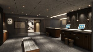 Een moderne receptie met een houten bank, een kaart aan de muur, een digitale kiosk en een wand van baksteen.