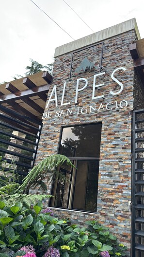 Um edifício com fachada de pedra e uma placa com a inscrição 'ALPES DE SAN IGNACIO'.