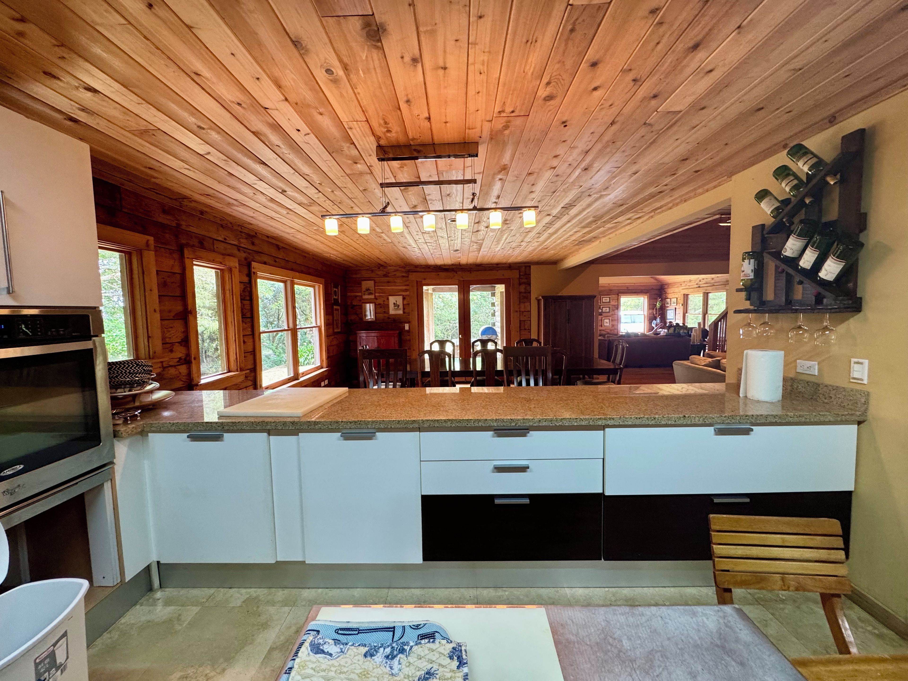 A kitchen with wooden ceiling, granite countertops, and a built-in oven.