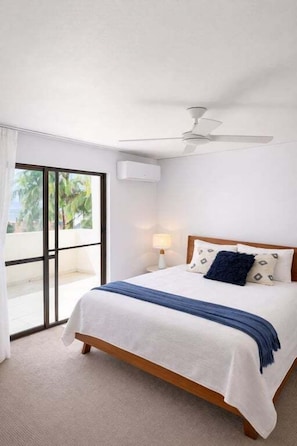 A bedroom with a bed, a ceiling fan, a window with a view, and a door leading to an outdoor area. - Blue Sea View - Mooloolaba (Mooloolaba)