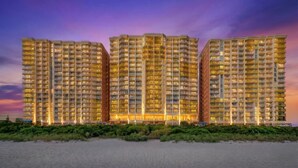 Un hôtel de grande hauteur doté de nombreux balcons, d’un toit plat et situé en bord de mer.