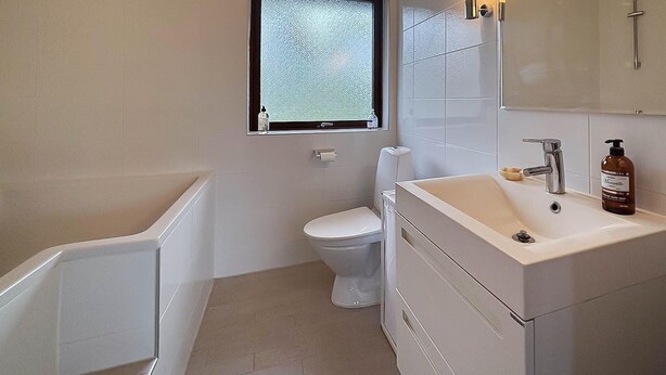 A bathroom with a toilet, a sink, a mirror, and a window. - 3 bedroom cozy home in Yngsjö (Yngsjö)