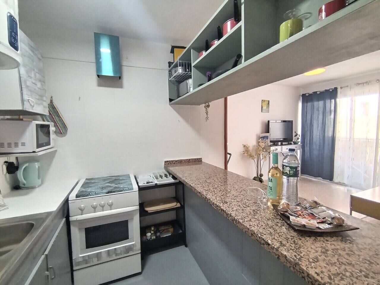 A compact kitchen with a microwave, stove, and countertop.