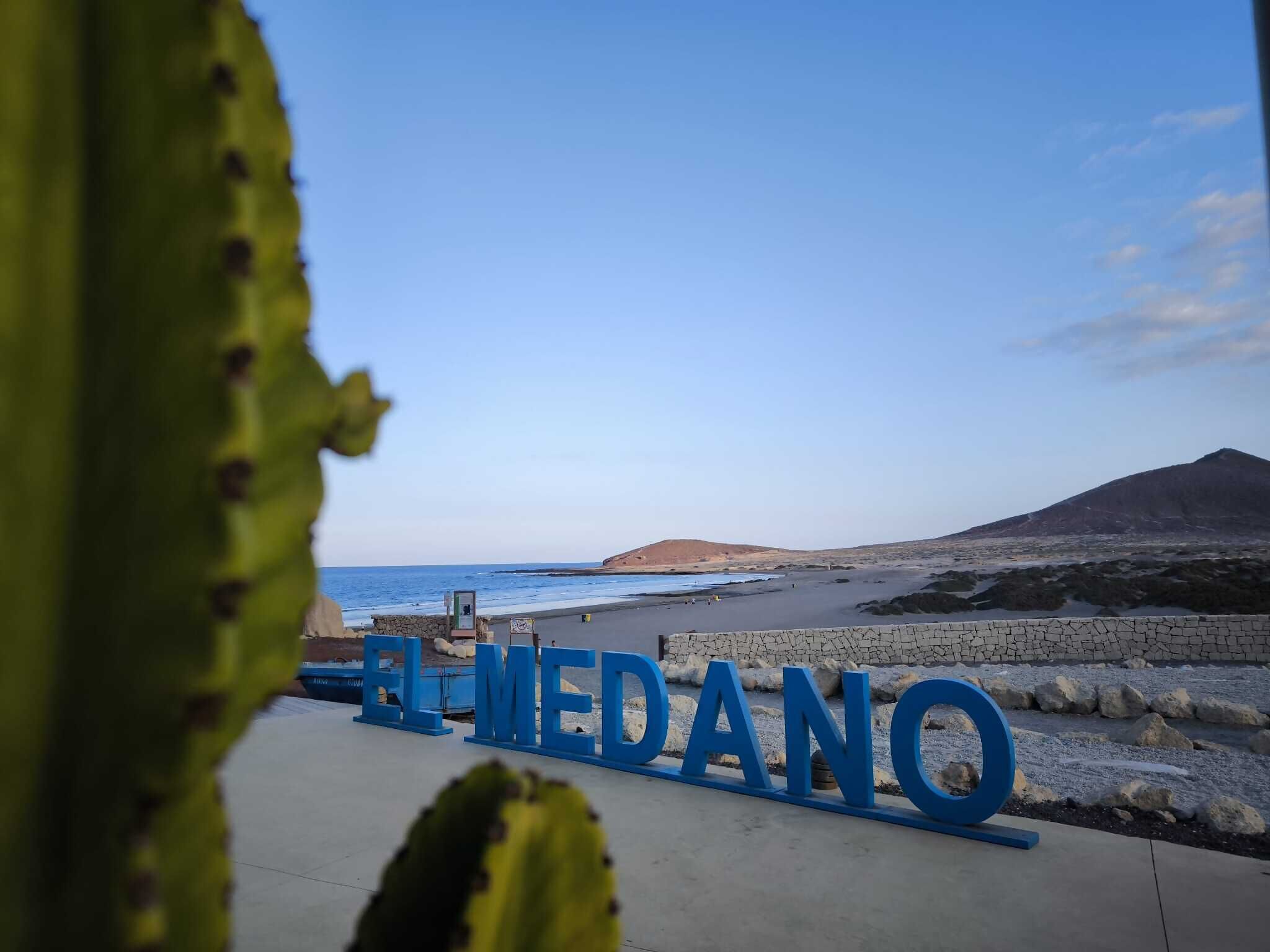 Blick auf einen Strand, mit dem Schriftzug 'EL MEDANO' deutlich sichtbar.