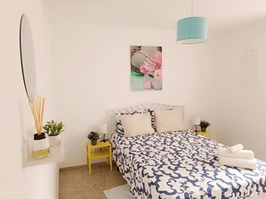 A bedroom with a bed, bedside tables, a hanging lamp, and wall-mounted plants. - Tenerife Sur El Médano Vacaciones - 3a (Medano, El)