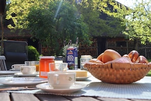 A breakfast table with a basket of bread, a milk carton, and a cup. - Apartment (B) with 1 bedroom and terrace 1-2 persons (Chieming)