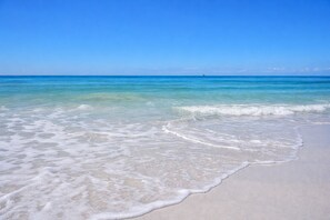 Una spiaggia con acqua cristallina e una riva sabbiosa.