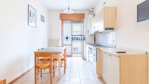 Une cuisine moderne avec un coin repas, des meubles en bois et une vue sur l’extérieur.