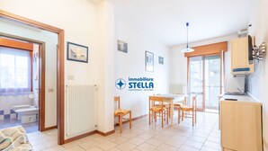 Un appartement moderne comprenant un coin repas, une cuisine et un logo bien visible de « immobiliare STELLA ».