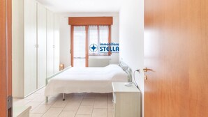Une chambre à coucher avec un lit, un bureau, une armoire et un radiateur.