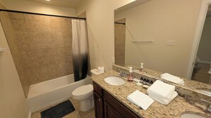 A bathroom with a bathtub, toilet, sink, and a large mirror. - Spacious 3BR Near AT&T Stadium-Global Life Field-Texas Live!-FIFA WorldCup2026 (Arlington)