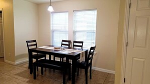 A dining area with a table, chairs, a bench, a ceiling light, and windows with blinds. - Spacious 3BR Near AT&T Stadium-Global Life Field-Texas Live!-FIFA WorldCup2026 (Arlington)