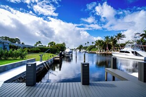 A marina with boats docked, a clear sky, and a calm waterway.