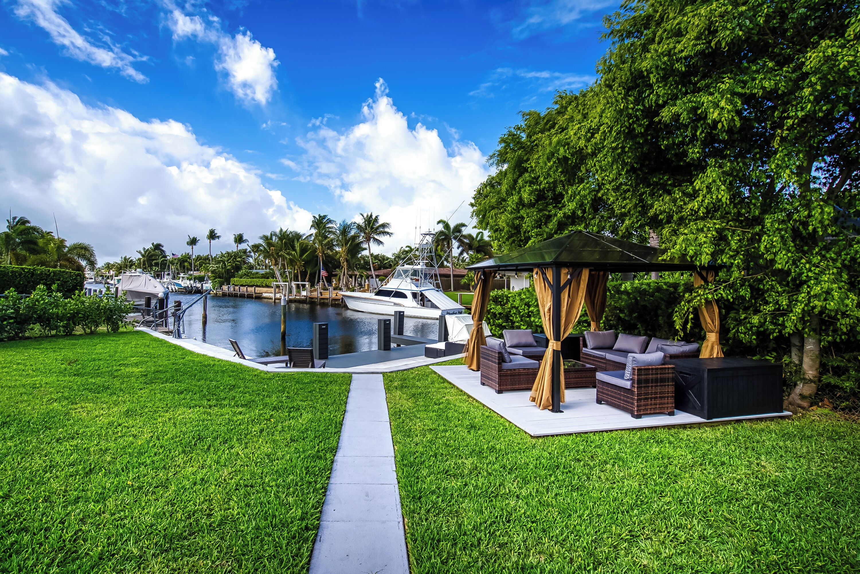 A pool area with a boat, outdoor furniture, and a pathway.