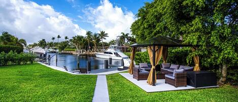 A pool area with a boat, outdoor furniture, and a pathway.