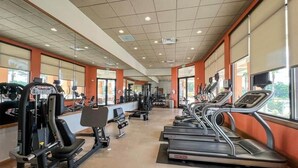 A gym with treadmills, weight machines, and a mirrored wall. - Disney, Resort Style, 4 BDRM, Sleeps 8, 3 Bath (Kissimmee)