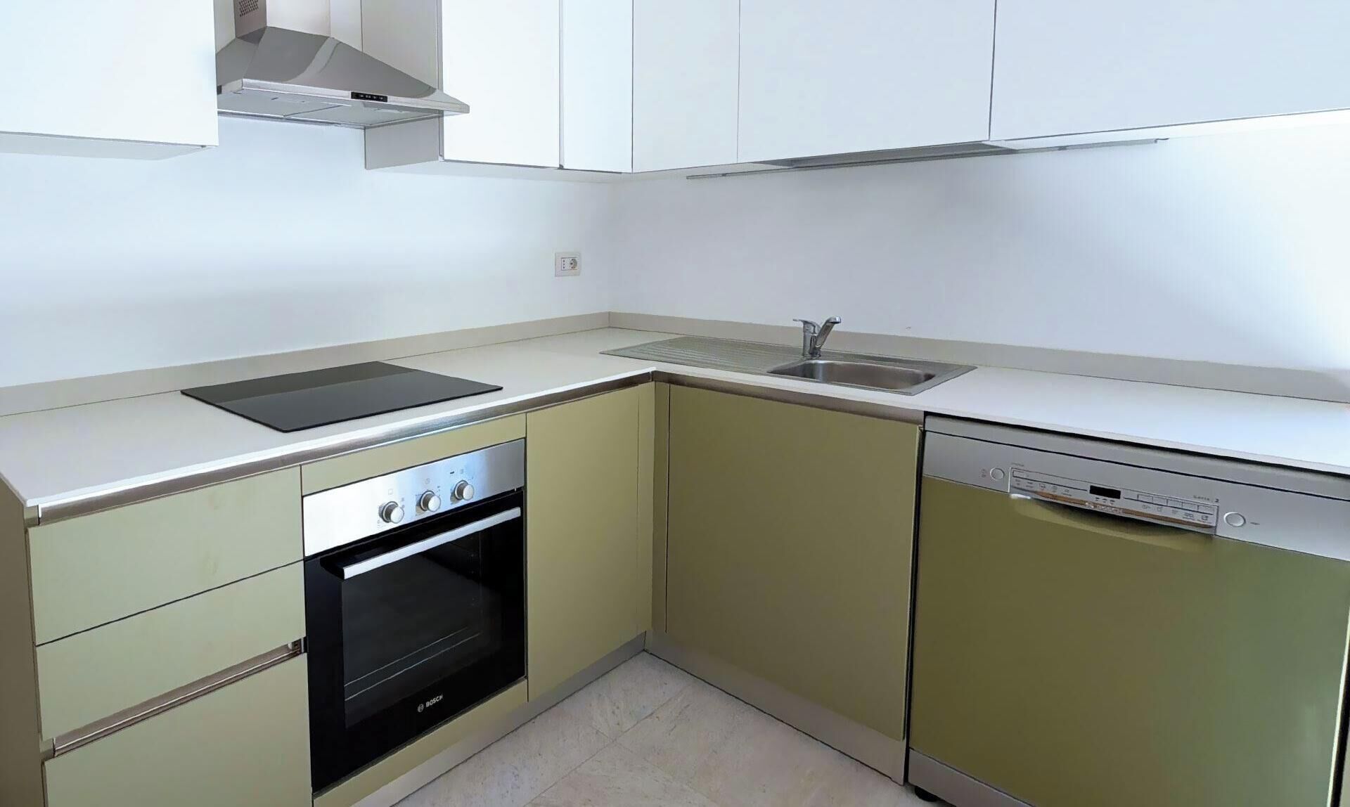 A compact kitchen with a built-in oven, a dishwasher, and a sink.